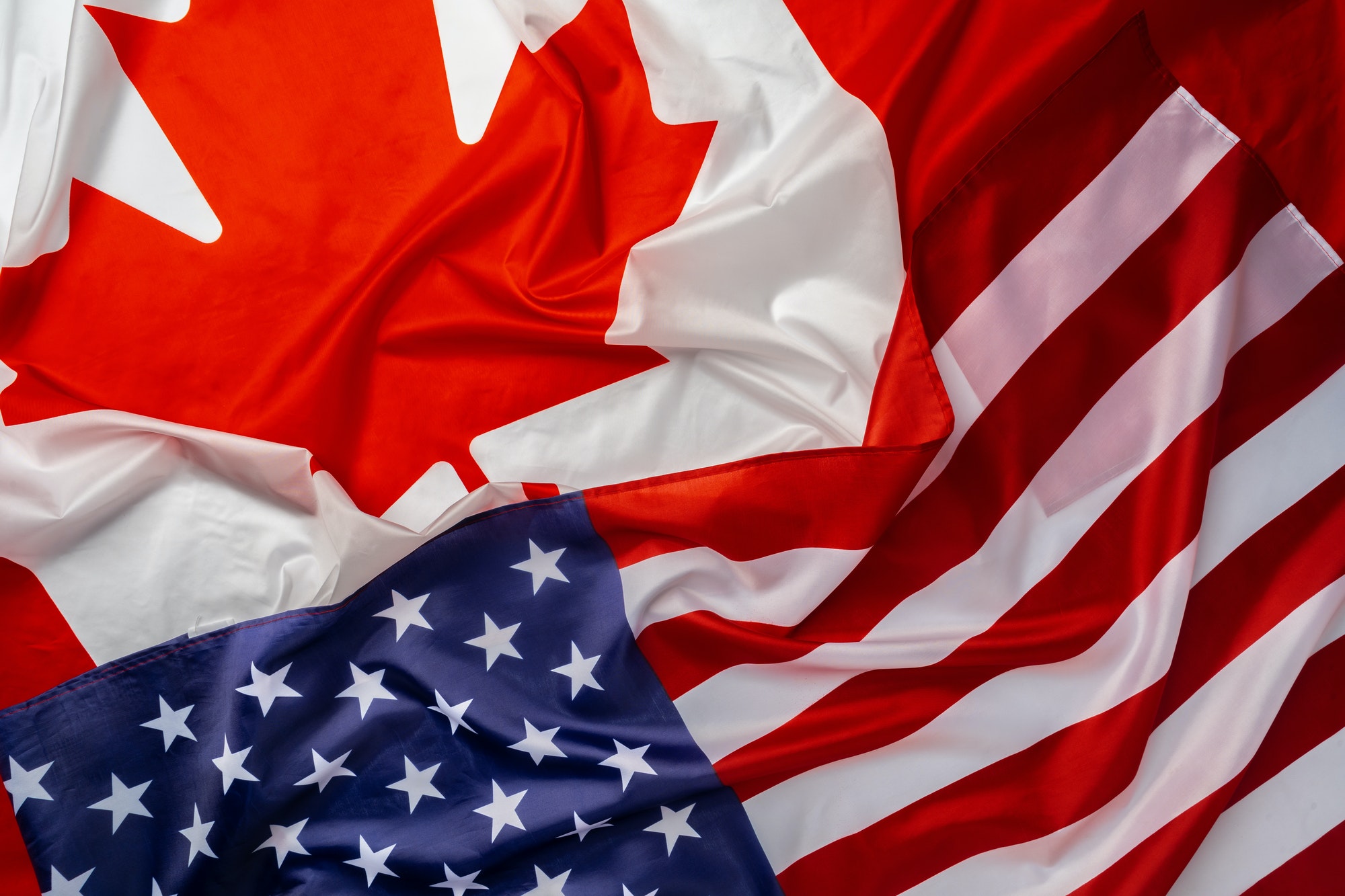 Flags of Canada and USA folded together
