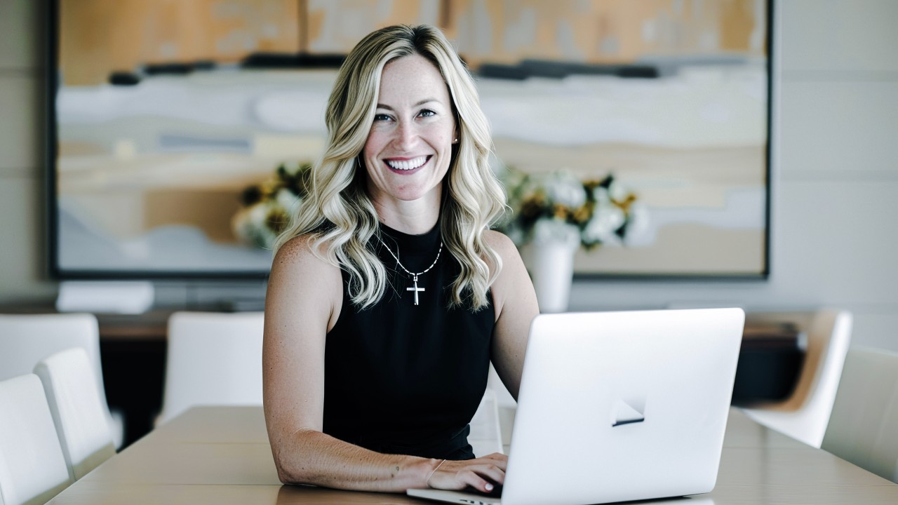 Image of lady in front of a laptop smiling.