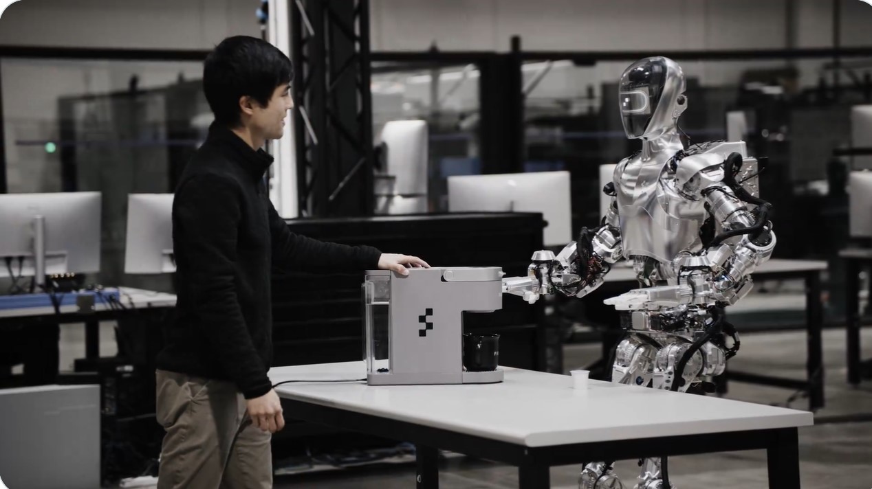 A man watching a robot make coffee