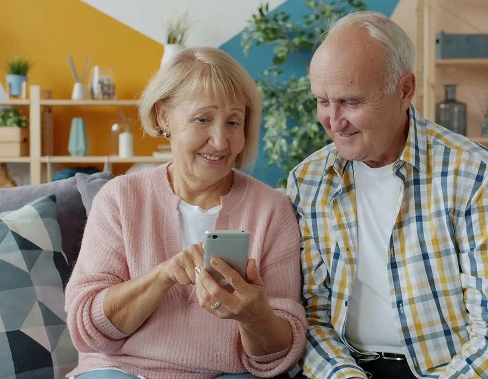 Happy retirees looking at phone