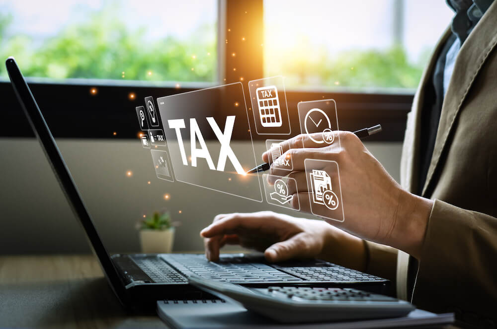 Man doing his taxes in front of a computer with animated financial projection in front of him