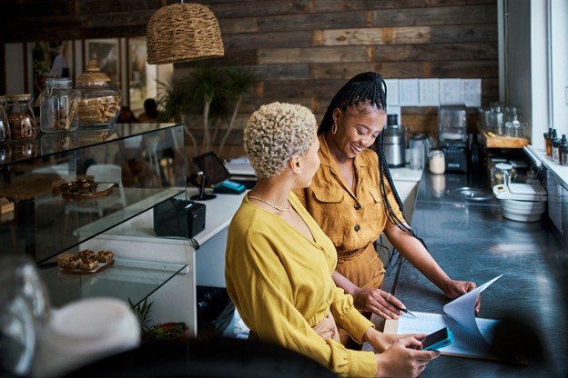 two ladies standing side by side talking