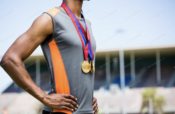 athlete posing with gold medals around his neck