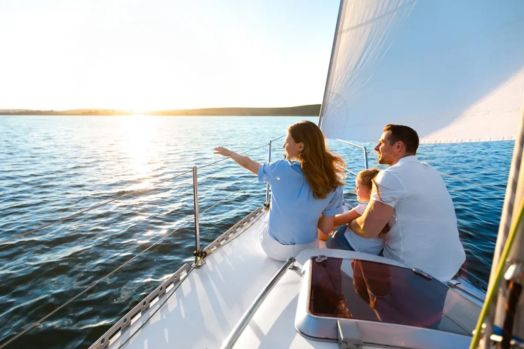 Family Sitting On Yacht Deck Sailing Across The Sea