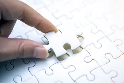 a hand placing a puzzle piece