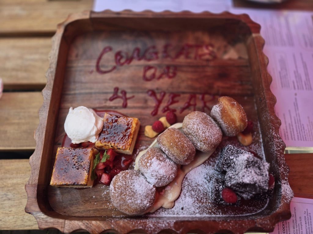 Dessert platter with the message 'Congrats on 4 Years' written in sauce, shared by the Wagner Investment Management Team.